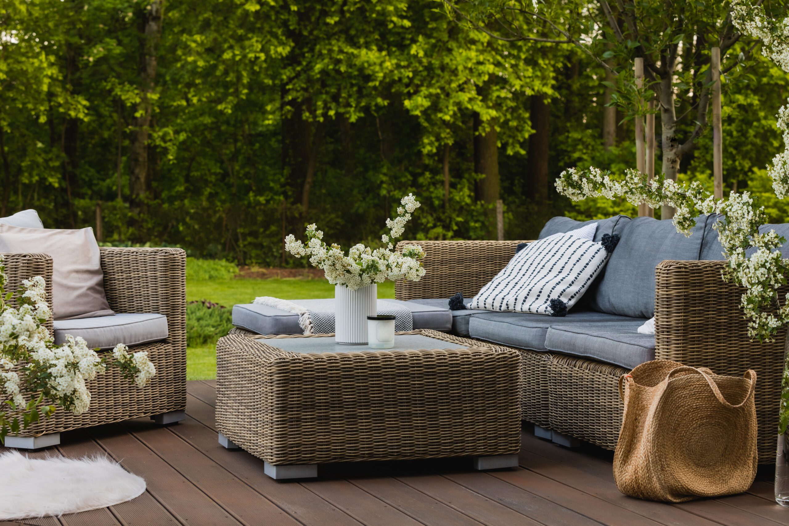 Outdoor wicker furniture with blue cushions.